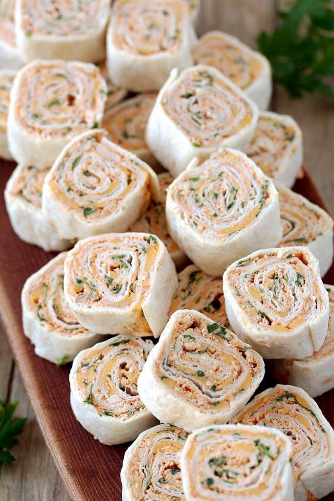Taco Tortilla Roll Ups this quick and easy party appetizer filled with cream cheese, sour cream, chicken, cheddar cheese, taco seasoning, taco sauce and parsley is perfect for every holiday or a party.