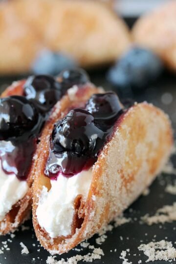 Blueberry Cheesecake Tacos - this is a recipe for very tasty dessert tacos. If you ask me, crunchy tortilla shells, filled with cheesecake filling and topped with homemade blueberry sauce make a perfect dessert.