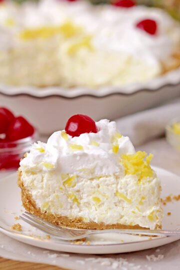 Pineapple Cream Pie - super quick and easy no bake recipe, ready in 10 minutes! Serve this creamy tropical flavor dessert for holidays, gatherings and parties, all year round, especially during summer and be sure your guests will enjoy it. A rich decadent creamy filling made of cream cheese and cool whip loaded with crushed pineapple and grated coconut on a graham cracker crust, topped with whipped topping and maraschino cherries is a tropical dream!
